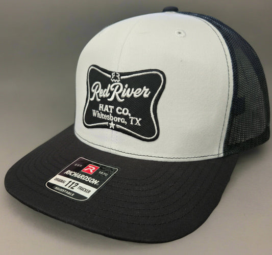 White and black cap with 'Red River Hat Co' logo on a gray background